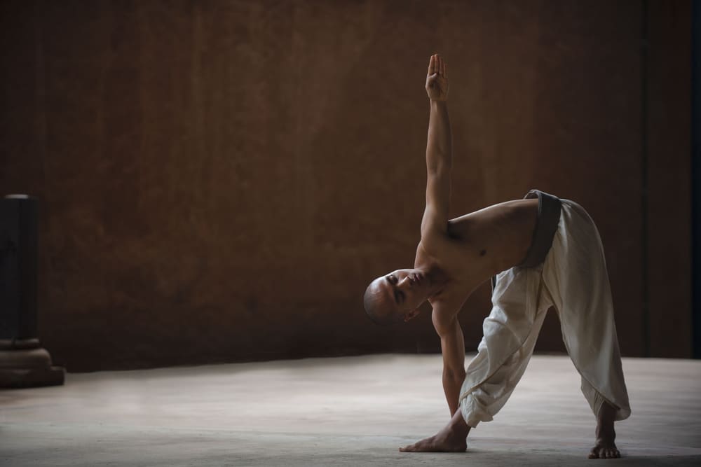 Une flexion latérale debout, un bras levé