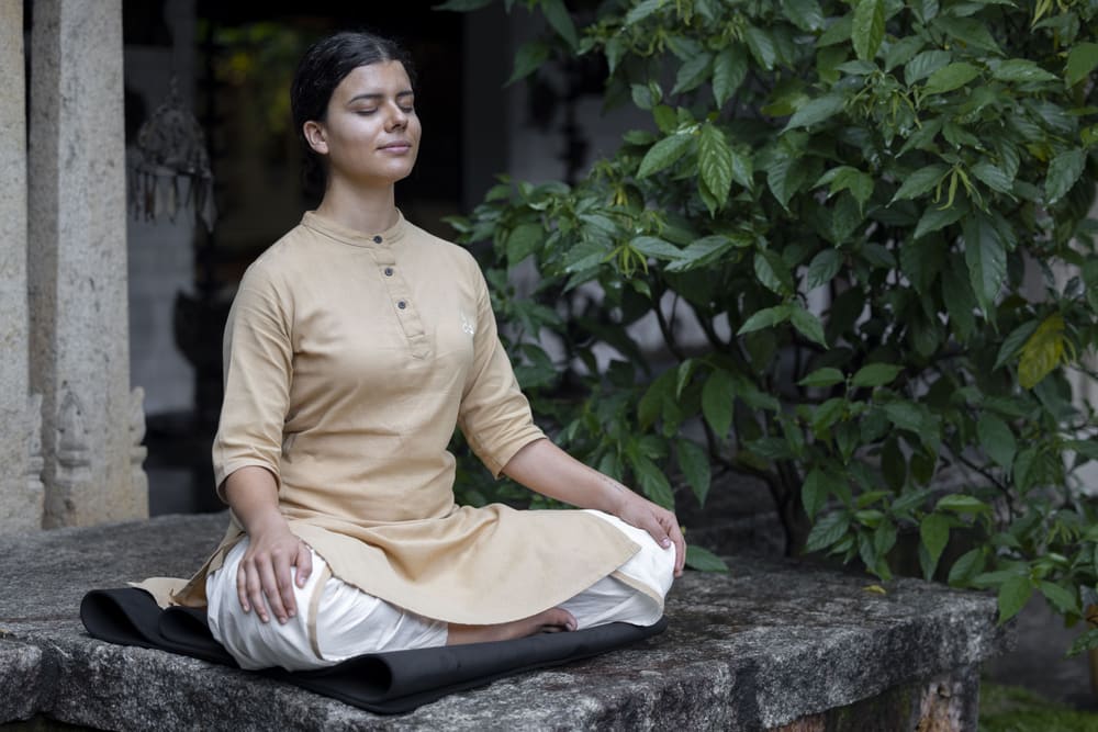 Une méditation assise sur une plateforme de pierre