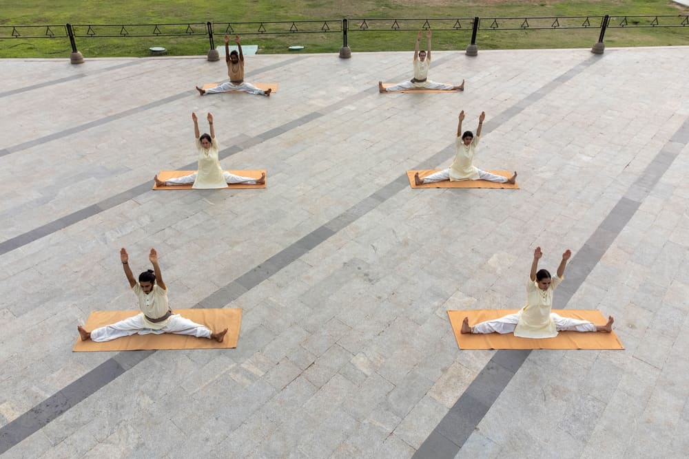 Des pratiquants sur leurs tapis dans la cour